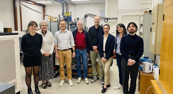 Groupe de personnes posant dans un laboratoire scientifique moderne.