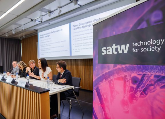 SATW banner next to a panel discussion in the conference room.