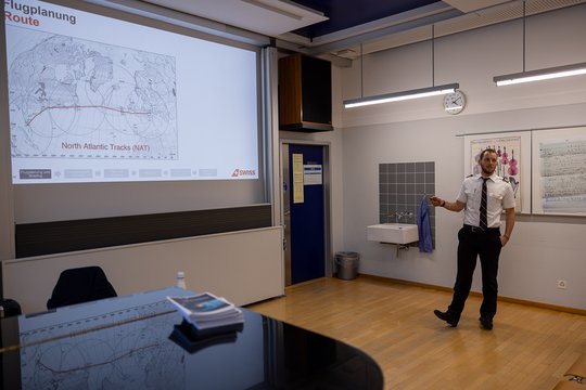 Pilot presents flight plan in front of a map.