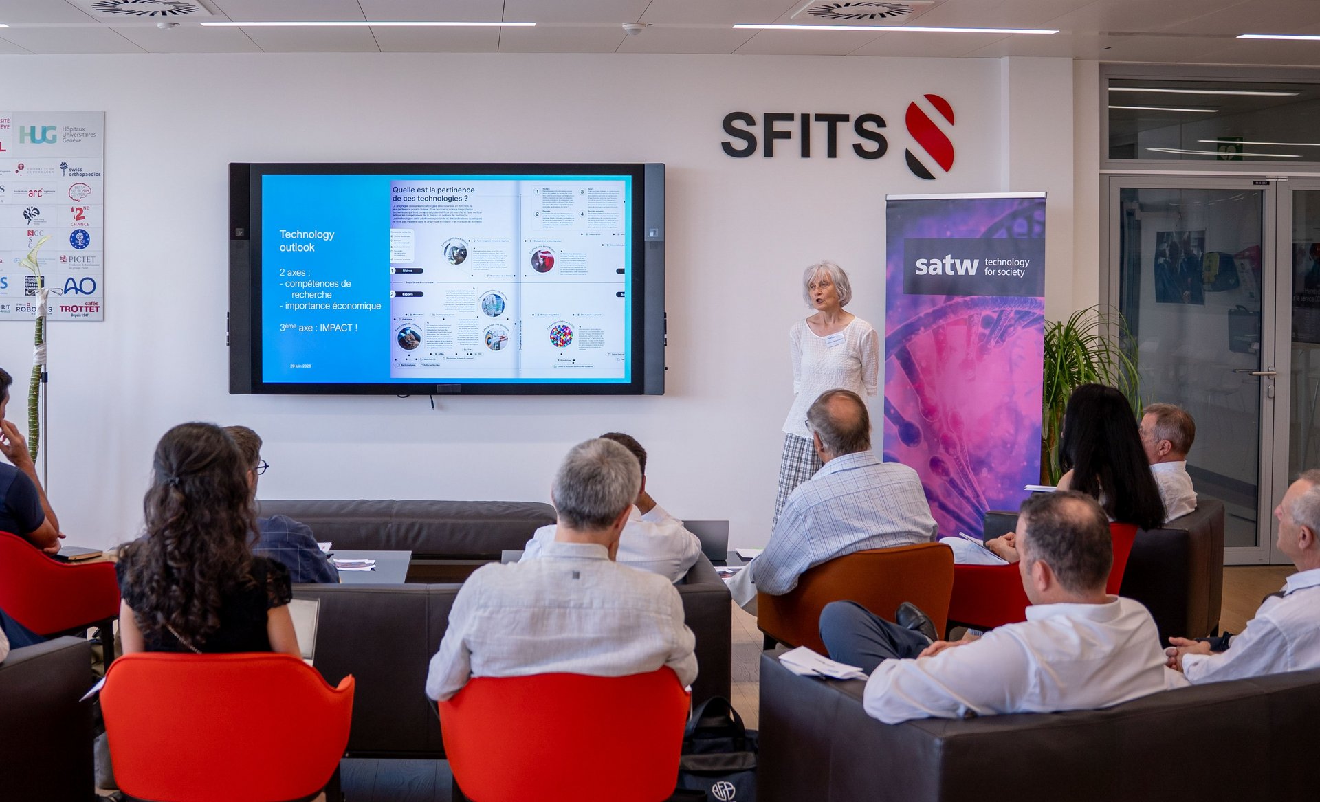 A presentation in a modern conference room with participants and a speaker